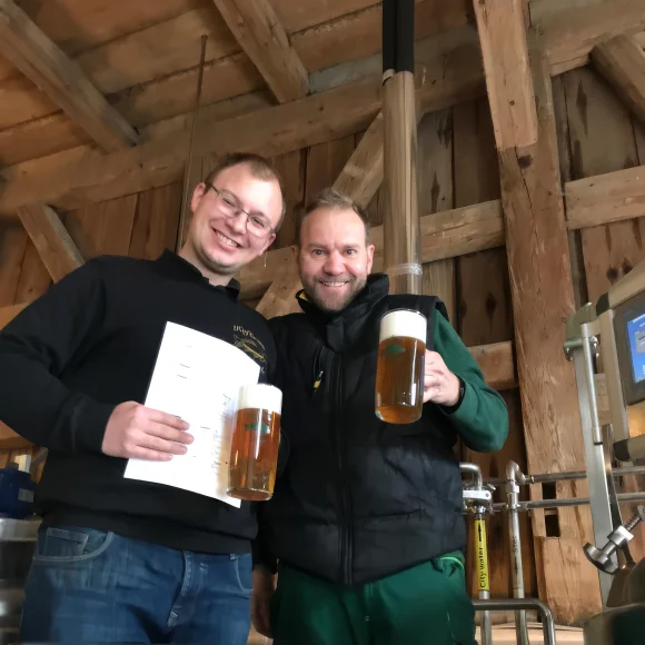 Die Brauer vom Hofbräu Oberle präsentieren ihr Bier mit Urkunde